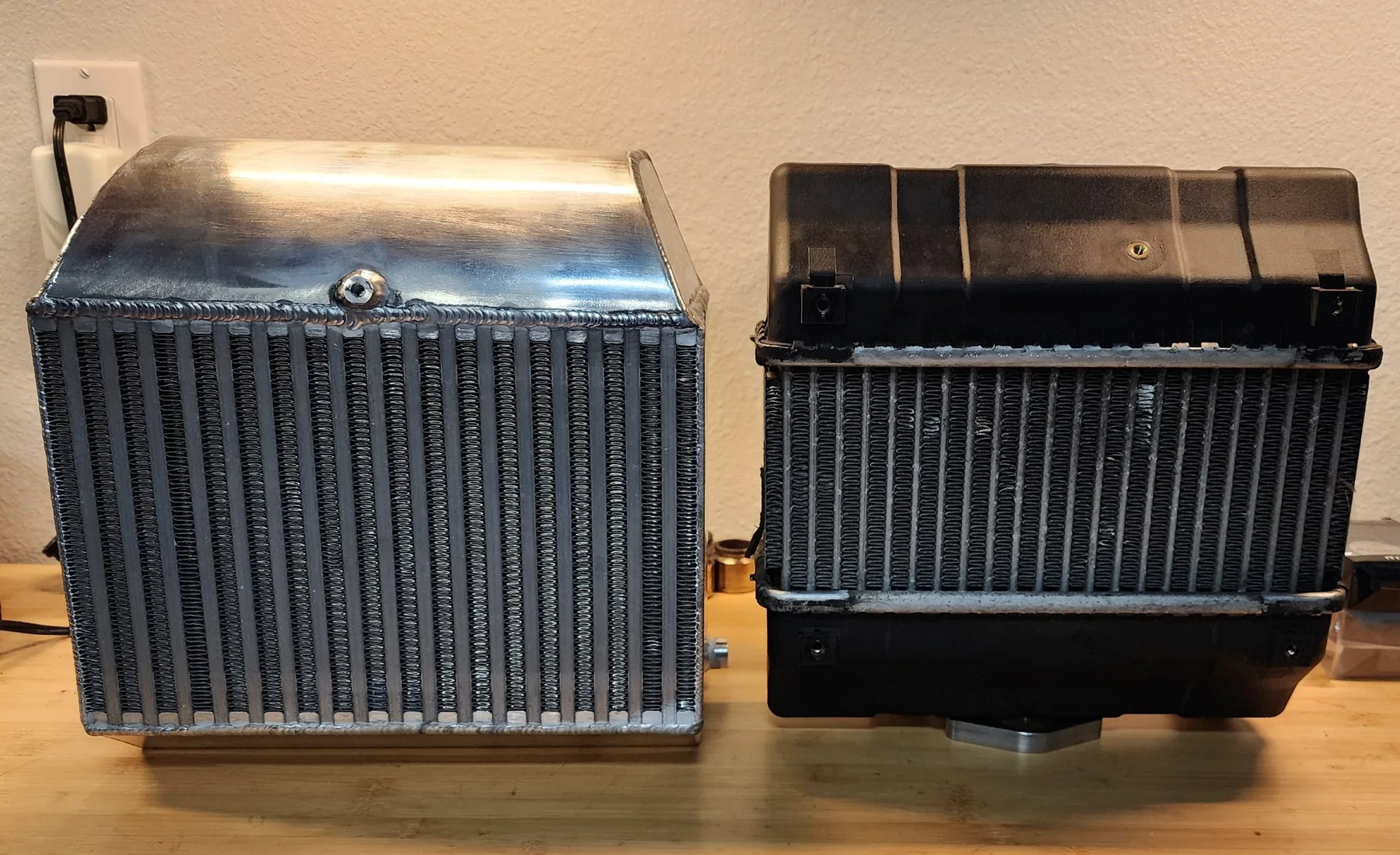 Custom aluminum intercooler positioned next to the original intercooler for comparison